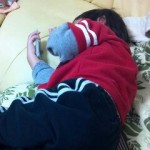 寝ながらiPod touchを操作してくつろぐデジタルエイジ